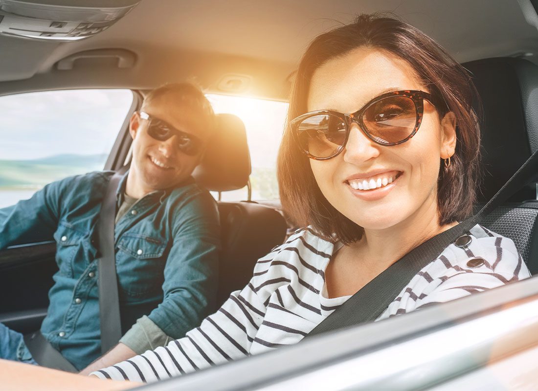 Personal Insurance - Cheerful Couple With a Long Auto Journey Ahead Riding in a Car